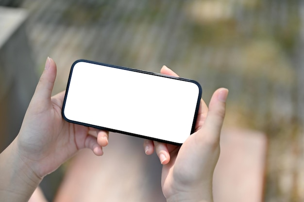 Un modello di schermo bianco per smartphone in posizione orizzontale nelle mani di una donna
