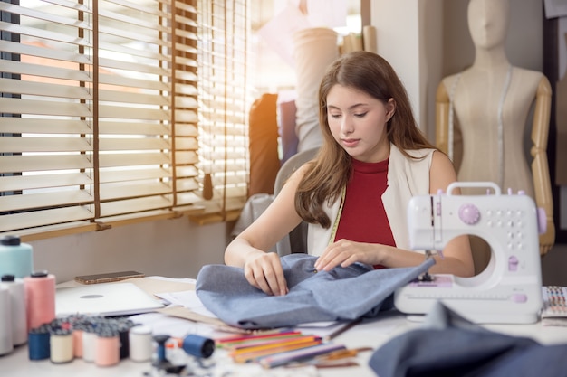 Un modello viene utilizzato da uno stilista per provare nuovi capi firmati. Al lavoro, un'imprenditrice nella sua attività di tessuti sta disegnando nuovi vestiti per uno stilista.