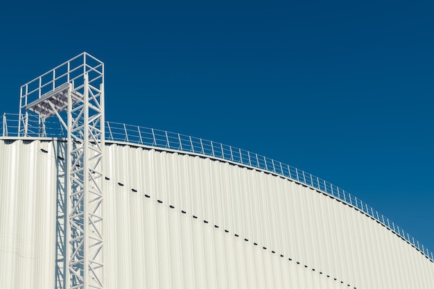 Un moderno hangar con una scala fino al tetto su sfondo blu cielo Copia spazio