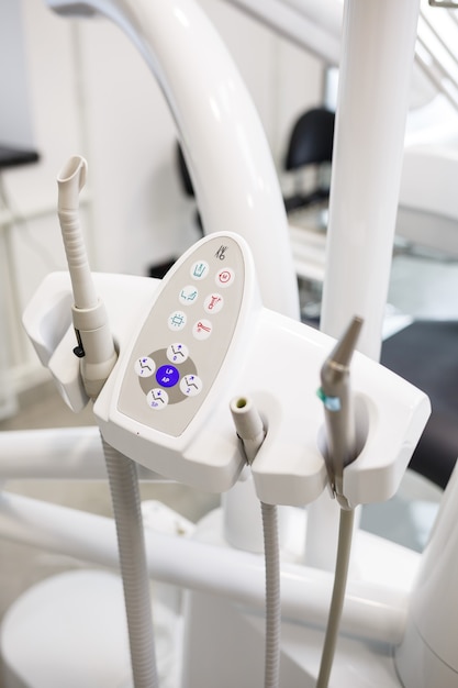 Un moderno studio dentistico con nuove attrezzature e una poltrona odontoiatrica. Mobiletto per cure odontoiatriche