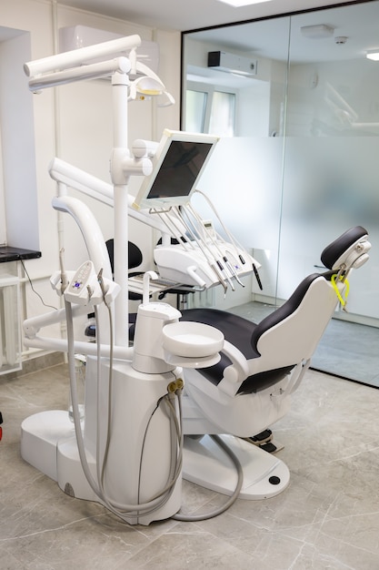 Un moderno studio dentistico con nuove attrezzature e una poltrona odontoiatrica. Mobiletto per cure odontoiatriche