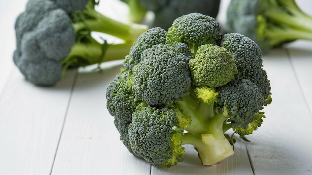 un mucchio di broccoli su un tavolo di legno con uno sfondo bianco