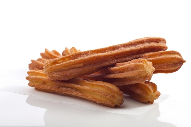 Un mucchio di churros seduto sopra una superficie bianca IA generativa