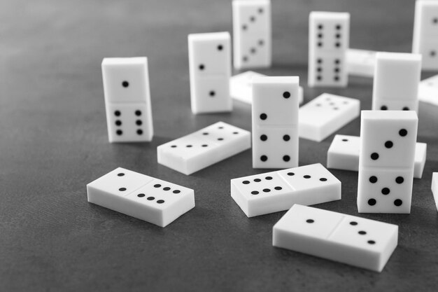 Un mucchio di domino su uno sfondo grigio