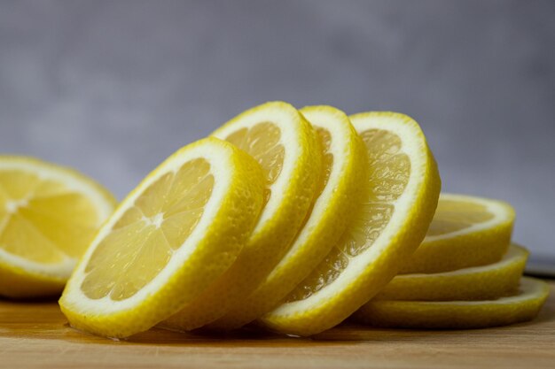 Un mucchio di limoni affettati su un tagliere di legno