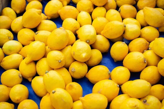 Un mucchio di limoni gialli maturi al mercato estivo da vendere come sfondo