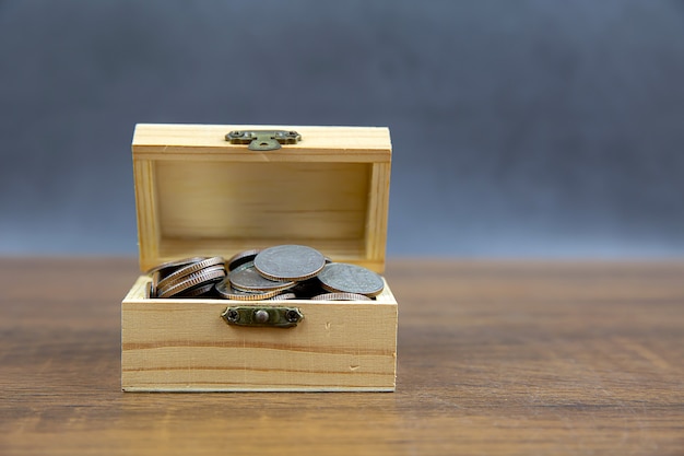 Un mucchio di molte monete in una cassa di legno Per idee di risparmio di denaro Pianificazione finanziaria e assicurazione.
