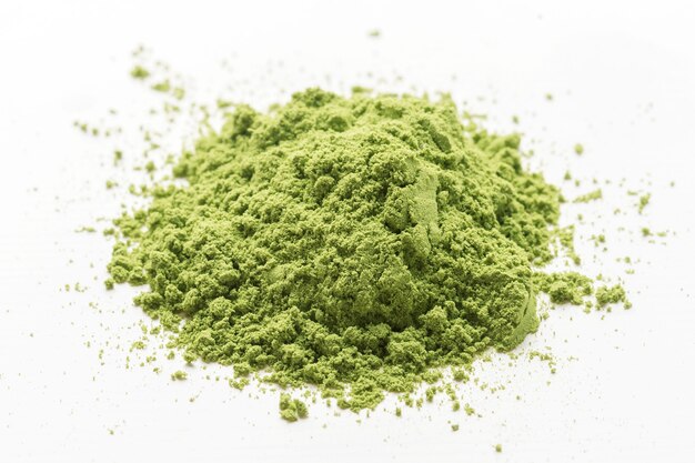 Un mucchio di polvere di tè matcha verde su un bianco isolato