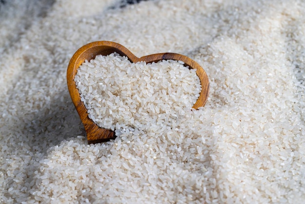 Un mucchio di riso bianco sul tavolo della cucina in un piatto di legno