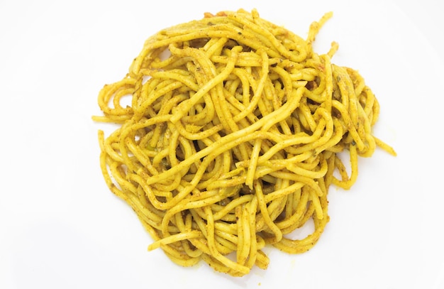 Un mucchio di spaghetti con sopra una salsa gialla.