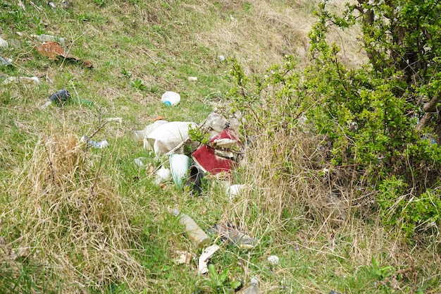 Un mucchio di spazzatura in una radura in campagna in una giornata di primavera Concetto di ecologia Fuori fuoco