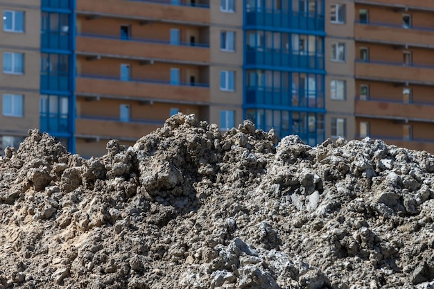 Un mucchio di terreno sporco sullo sfondo della facciata di un condominio