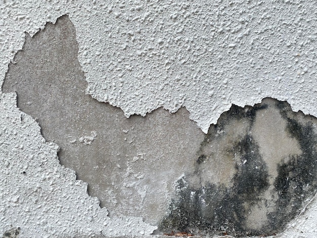 Un muro che è stato dipinto di bianco e ha un sacco di vernice su di esso.