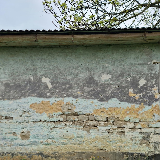 Un muro con un tetto di lamiera blu e un tetto verde.