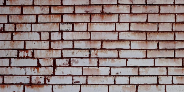 Un muro di mattoni con segni di ruggine su di esso
