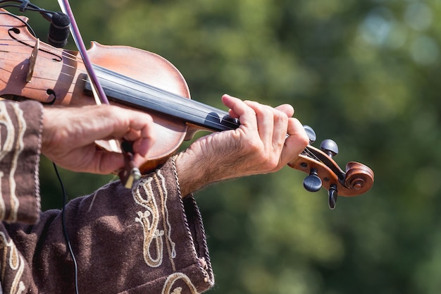 Un musicista in un vecchio costume suona il violino_