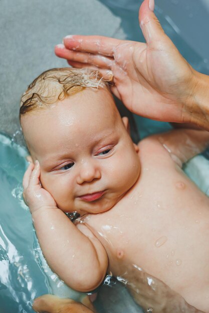 Un neonato fa il bagno I genitori fanno il bagno al bambino Il neonato viene fatto il bagno Il neonato sorride