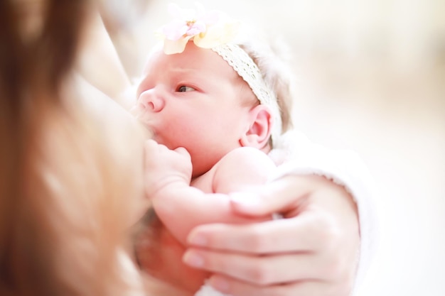 Un neonato giace tra le braccia di sua madre Un bellissimo bambino dall'aspetto europeo sta dormendo