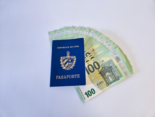 Un normale passaporto cubano con diverse banconote in euro su uno sfondo bianco