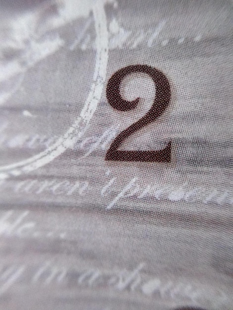 Un numero 2 è su un tessuto grigio e bianco.