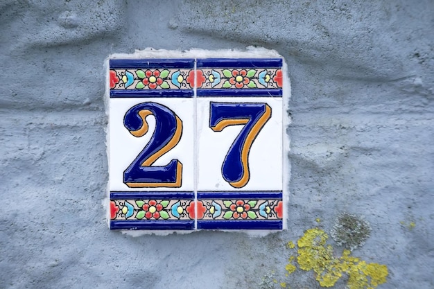 Un numero su un muro di cemento grigio con motivi blu e arancioni e linee blu scuro