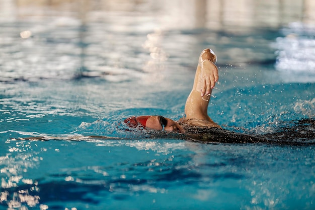 Un nuotatore sta nuotando in stile strisciamento in piscina