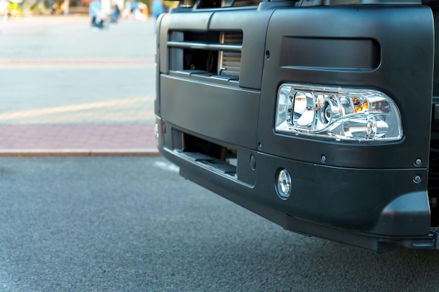 Un nuovo camion con un rimorchio sulla strada Dettagli del camion in primo piano Nuovi fari e ruote dell'auto Il concetto di trasporto merci