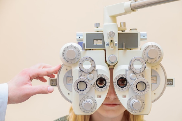 Un oftalmologo maschio controlla la vista di una ragazza usando un phoropter trattamento della visione