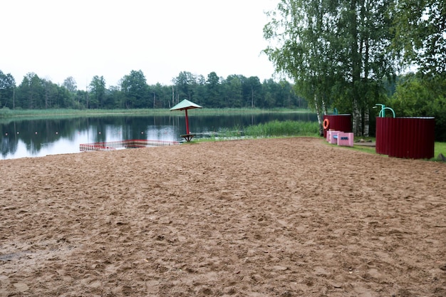 Un ombrello affondato solitario e recintando un box per fare il bagno ai bambini su una spiaggia sabbiosa