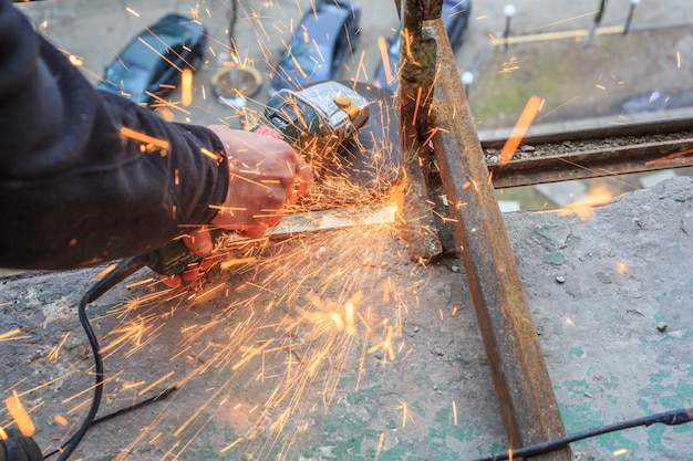 Un operaio taglia il metallo con una smerigliatrice