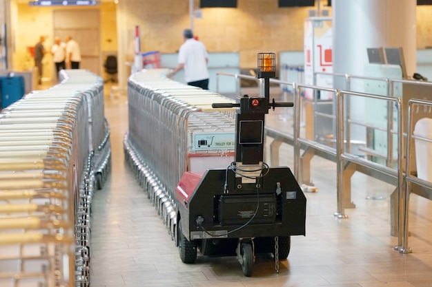 Un operaio trasporta i carrelli per i bagagli all'aeroporto.