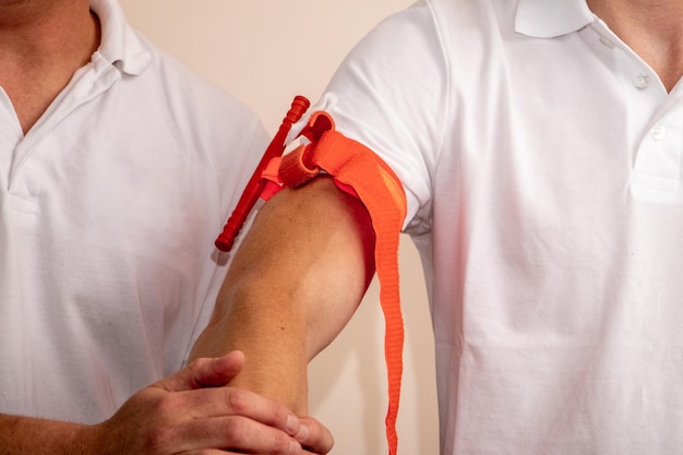 Un operatore sanitario mostra come applicare un laccio emostatico al braccio per fermare l'emorragia in caso di infortunio o incidente