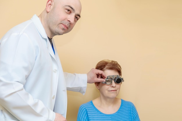 Un optometrista controlla la vista di una donna adulta con un telaio di prova