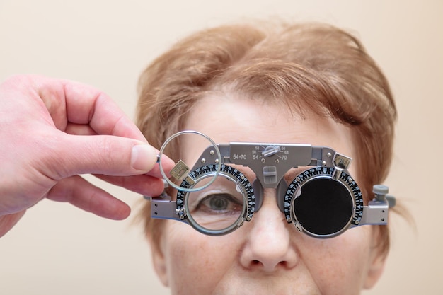 Un optometrista controlla la vista di una donna adulta con un telaio di prova