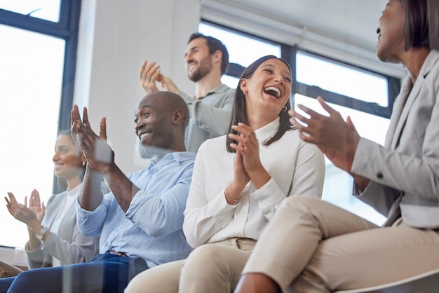 Un'ora di risate. Inquadratura ritagliata di un gruppo di uomini d'affari che applaudono seduti in ufficio durante una conferenza.