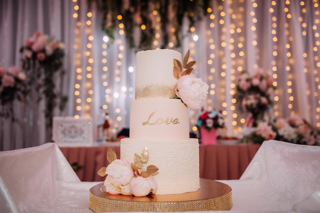 Un'originale torta nuziale alta decorata con fiori e foglie 3813