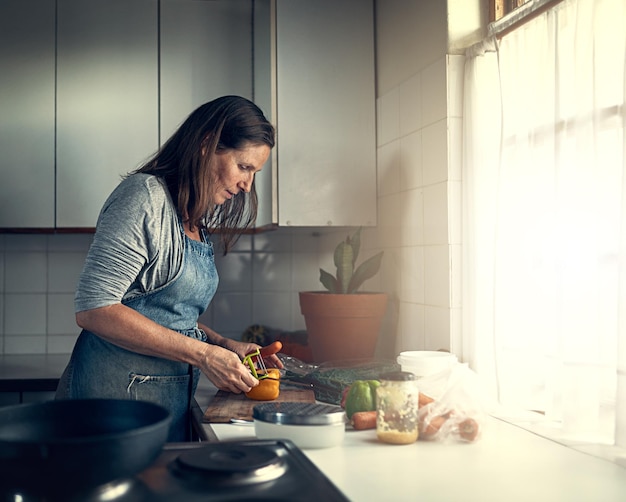 È un'ottima cuoca di casa Colpo di una donna matura che prepara un pasto nella sua cucina a casa