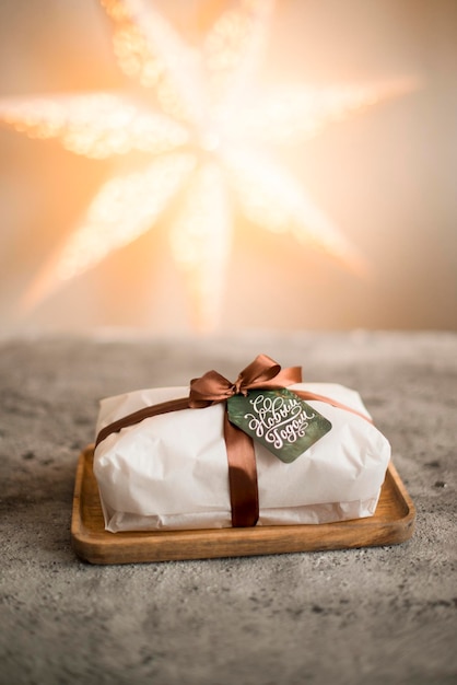 Un pacco di Natale decorato con un nastro si trova con l'etichetta Happy New Year