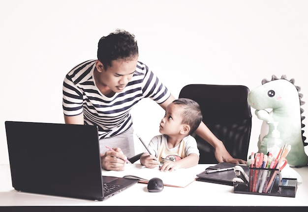 Un padre aiuta il figlio con lezioni online sul laptop isolamento dell'apprendimento a distanza rimanere a casa quarantena ed epidemia Concetto di apprendimento online