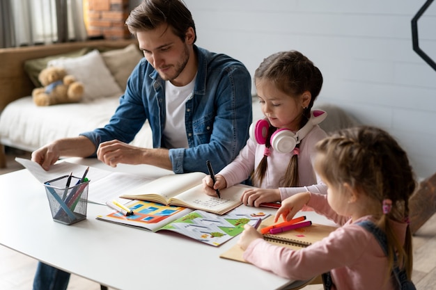 Un padre che aiuta la sua piccola figlia a fare i compiti per la scuola.