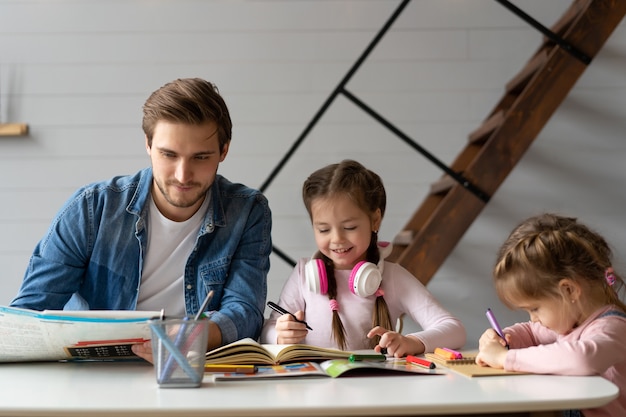 Un padre che aiuta la sua piccola figlia a fare i compiti per la scuola.