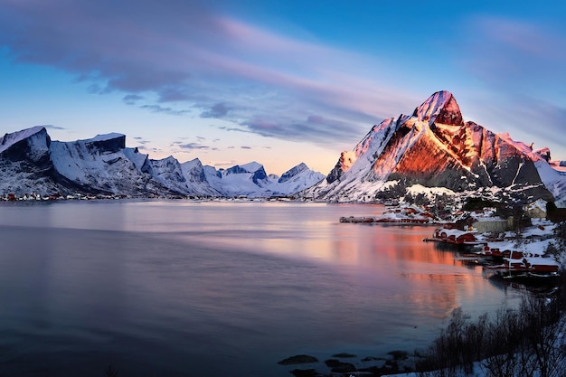 Un paesaggio montano innevato con un lago e montagne in primo piano.