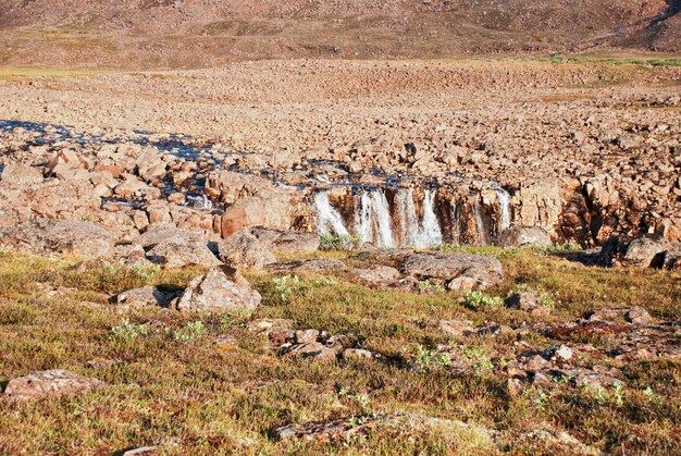 Un paesaggio roccioso con una cascata