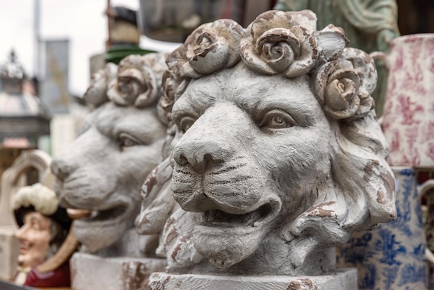 Un paio di antichi vasi decorativi per piante a testa di leone con rose che formano la criniera