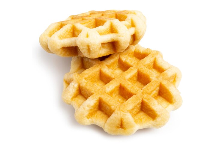 Un paio di cialde al burro rotonde appena sfornate Dessert belga di pasticceria per la colazione isolato su bianco