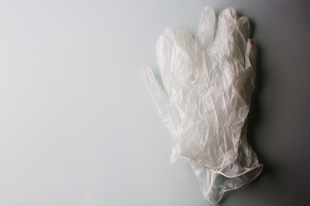 Un paio di guanti in lattice medico su uno sfondo grigio con un'ombra. Spazio per il testo