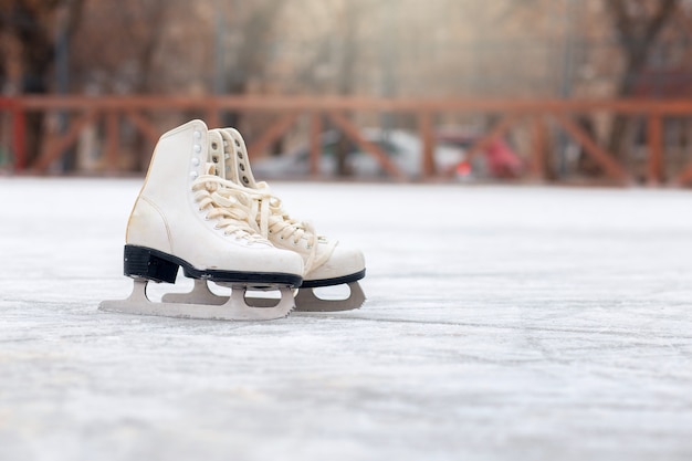 Un paio di pattini bianchi sono in piedi su una pista di pattinaggio aperta. Sport invernali