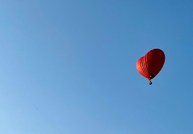 Un palloncino rosso in un cielo blu.