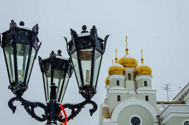 Un palo con lanterne sullo sfondo della chiesa.