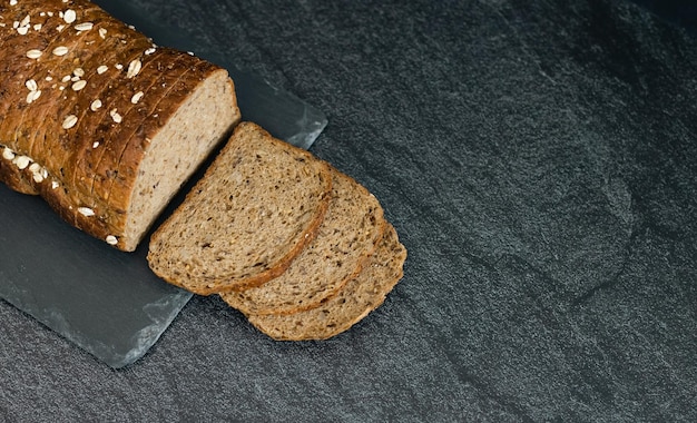 Un pane a fette con semi di segale su sfondo nero